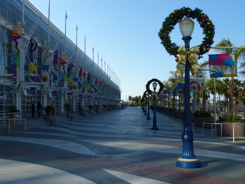 Photograph illustrating relative size.  There are light poles with wreaths on them.  As the poles appear farther, it is clear that they are smaller in the image.