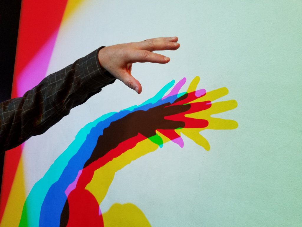 Goes with the last image.  A hand in front of the wall.  In different areas it blocks different primaries, leading to showing the subtractive color primaries.
