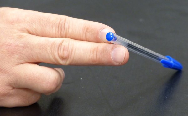 A pen resting between the tips of the first and second finger.  Links to a larger version of the picture.